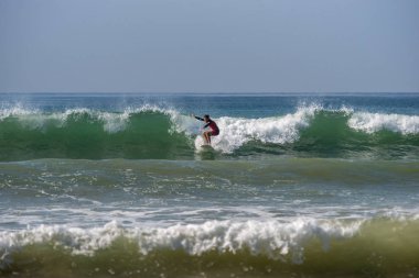 Weligama, Sri Lanka - 09 Ocak 2017: büyük bir dalga Weligama plajda sörf kimliği belirsiz adam
