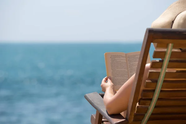Libro di lettura nelle mani della spiaggia tenendo libro — Foto Stock