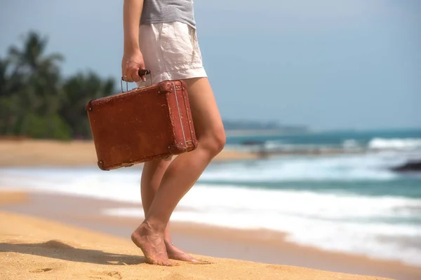 Hermosa chica con una vieja maleta vintage en una playa — Foto de Stock