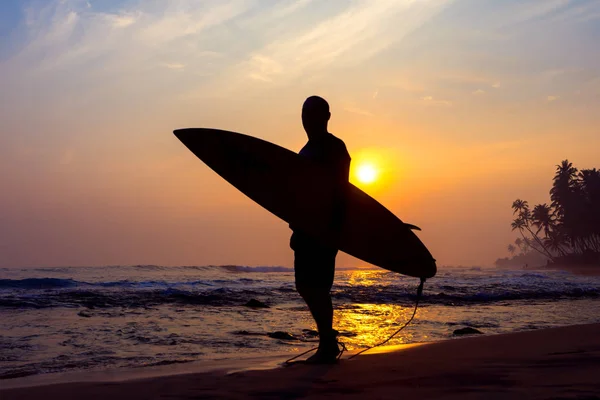 De mannelijke figuur met een bord voor surf op een achtergrond van Oceaan w — Stockfoto