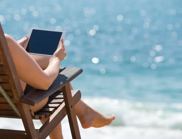 在海滩上的妇女手中的空白空平板电脑 — 图库照片