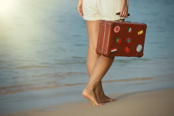 Schönes Mädchen mit einem alten Vintage-Koffer am Strand — Stockfoto