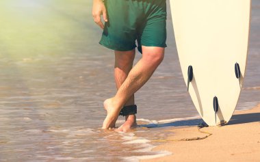 Genç güzel sörfçü erkekler plajda sörf tahtası gün kopma ile