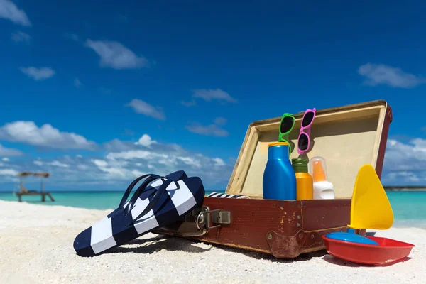Strand accessoires In koffer op strand - reizen Concept — Stockfoto
