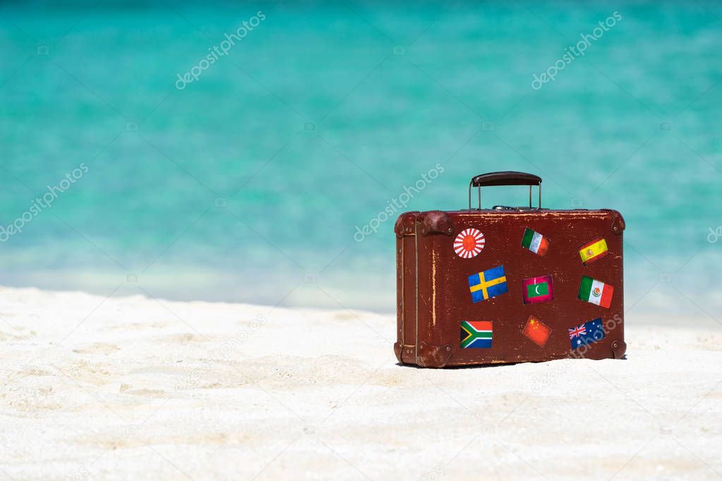 Travel  vintage suitcase is alone on a beach