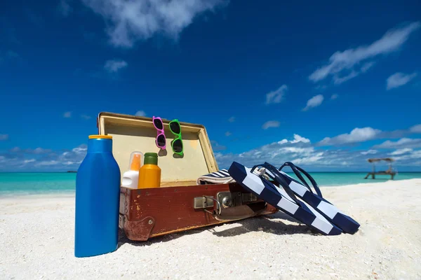 Strandzubehör im Koffer am Strand - Reisekonzept — Stockfoto