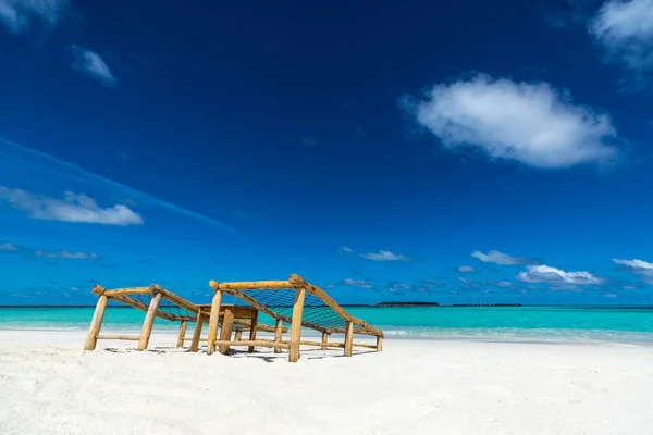 空的木制沙滩椅上的热带海滩度假。Trave — 图库照片