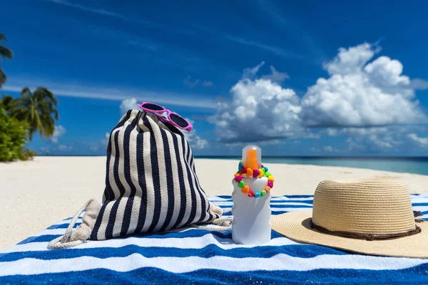 Sunscreen, hat and sunglasses on tropical beach — Stock Photo, Image