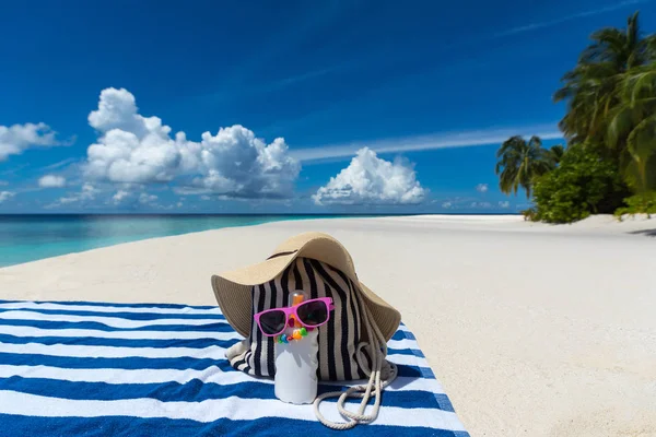 Sunscreen, hat and sunglasses on tropical beach — Stock Photo, Image