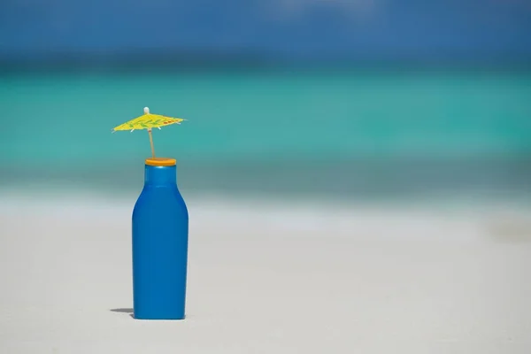 Garrafa de creme protetor solar na praia — Fotografia de Stock