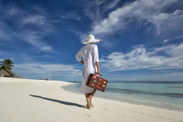 Mooi meisje met een oude vintage koffer in een strand — Stockfoto