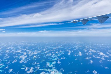 Mavi bulutların üzerinde uçan uçak kanadı.