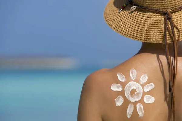 Vrouw met zon-vormige zon crème op strand — Stockfoto
