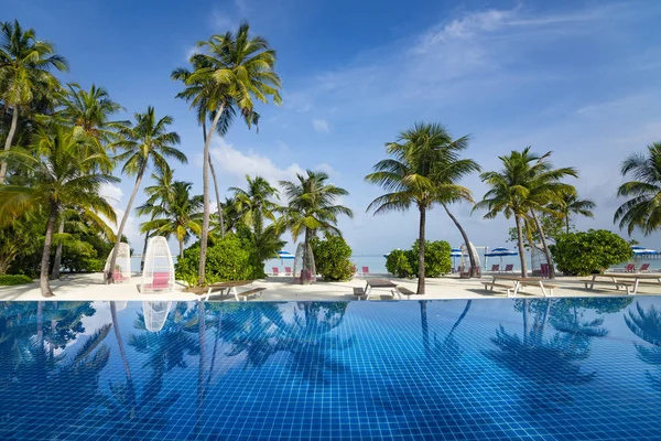 Hermosa playa y piscina. Vista de la bonita playa tropical con palmeras — Foto de Stock