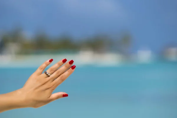 Bliska kobieta palec pokazując pierścień zaręczynowy na tropikalnej — Zdjęcie stockowe