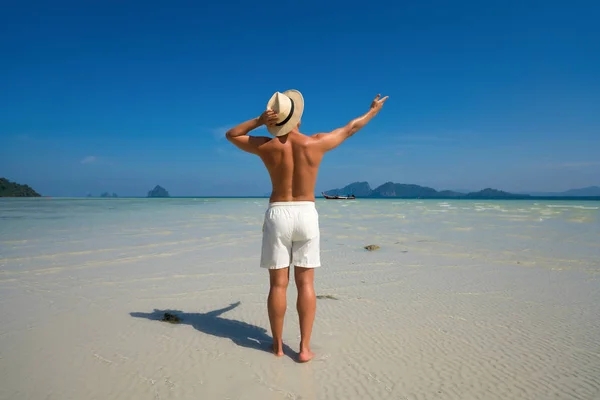 Sexy muž s svalnatým trupem těšit slunečný den na pláži Thajsko. — Stock fotografie