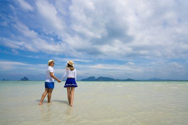 Yaz tatilinde tropik plajda genç mutlu bir çift. Taylan