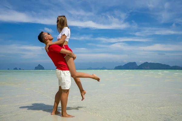 Ευτυχισμένο ζευγάρι στην αγάπη στην παραλία καλοκαιρινές διακοπές. Χαρούμενο κορίτσι pigg — Φωτογραφία Αρχείου