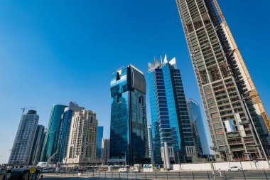 DOHA, Katar - 23 Kasım 2019: Doha, Katar 'da güzel mavi bir gökyüzü gününde Batı Körfezi Şehri silueti. Batı Körfezi, Doha 'nın en önemli bölgelerinden biridir..