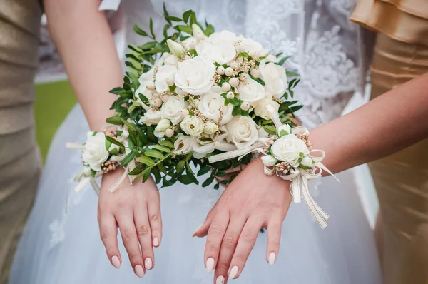 Boeketten van bloemen in de handen van de bruid en bruidsmeisjes — Stockfoto