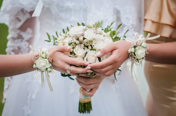 Bouquets de fleurs entre les mains de la mariée et des demoiselles d'honneur — Photo