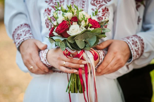 Brudgummen och bruden håller Colorfull bröllop bukett i handen — Stockfoto