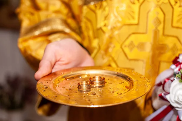 Anillos de boda de oro en la placa de oro en la iglesia — Foto de Stock