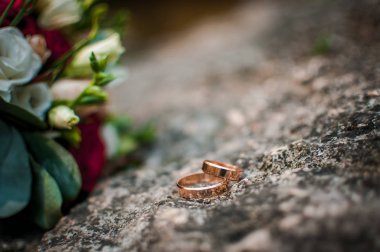 Taşın üzerinde bir çift altın alyans.