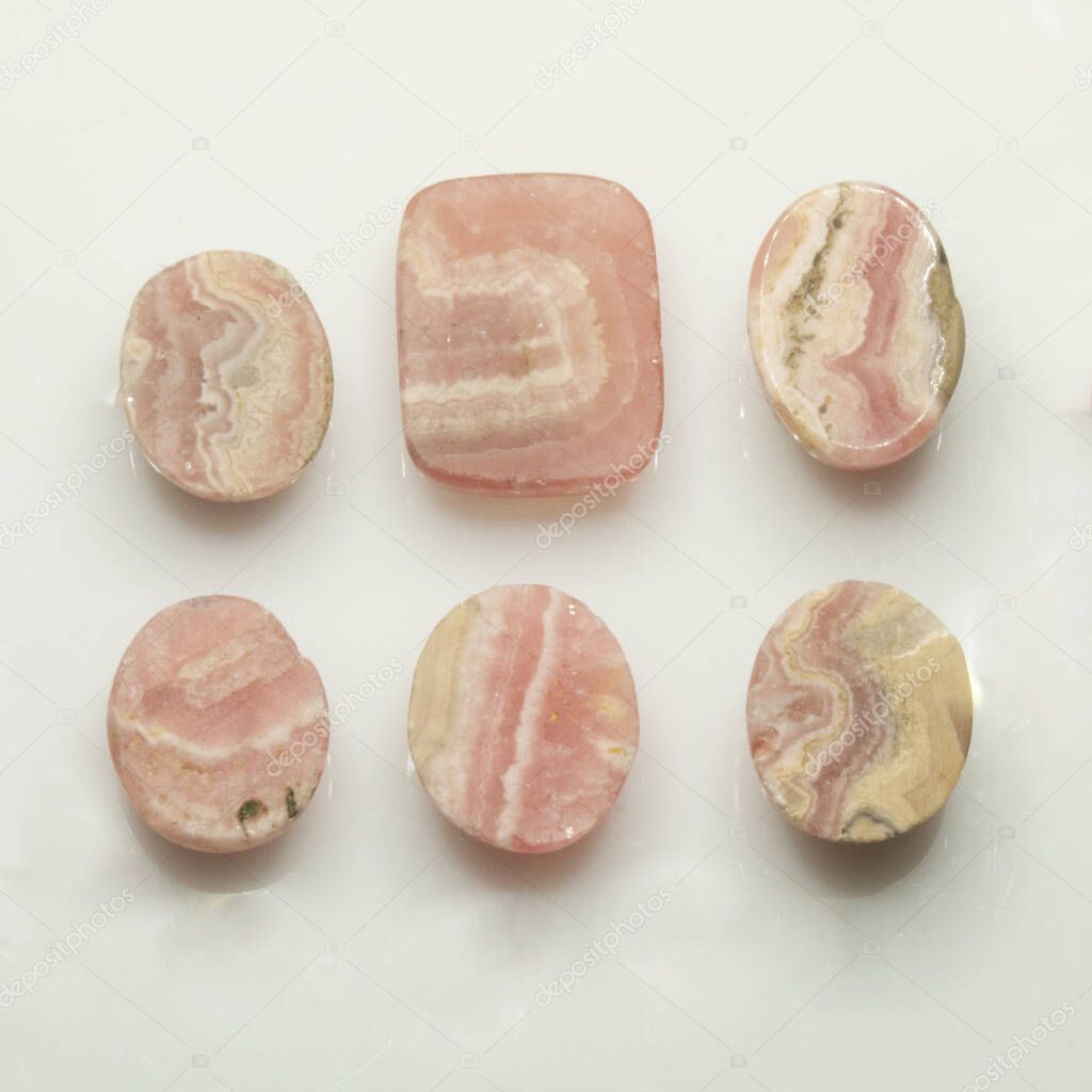 Natural rhodochrosite cabochon on the white background
