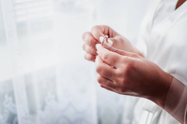 Gelinin elinde altın elmas alyans var.