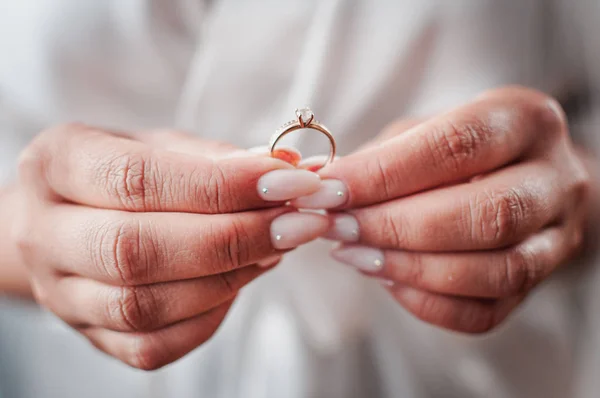 Невеста держать золотой бриллиант обручальное кольцо в руке — стоковое фото
