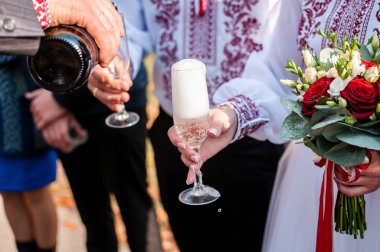 Adam arkadaşları için şarap kadehlerine şampanya dolduruyor.
