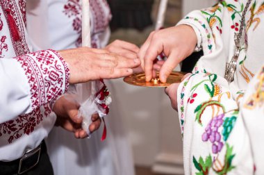 Rahip alyansları parmağına takar.
