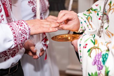 Rahip alyansları parmağına takar.