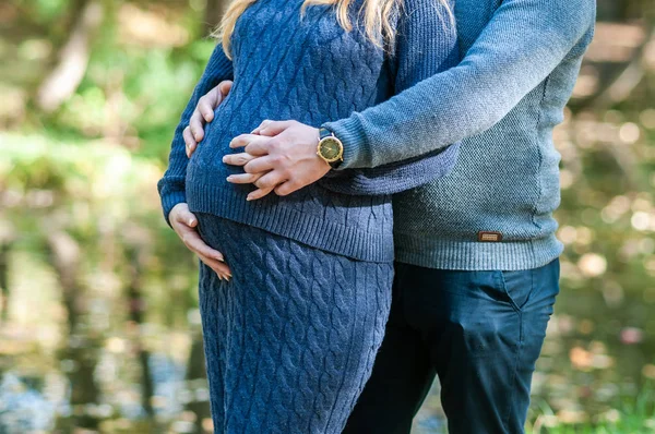 Donna incinta e uomo si tengono per mano a forma di cuore — Foto Stock