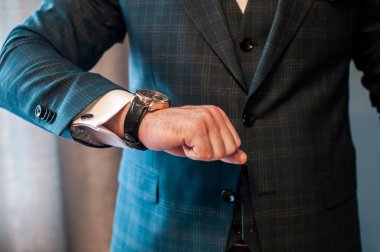 Damat bileğine saat takar.