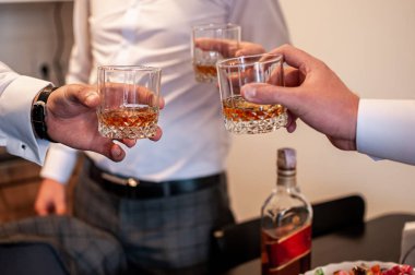 Erkekler bardakları viskiyle tokuşturur