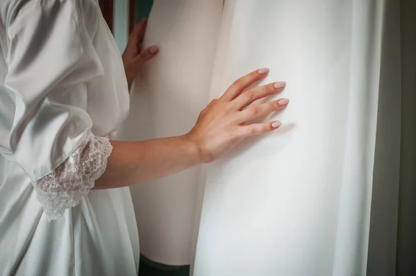 Nevěsta dává ruku na svatební šaty — Stock fotografie
