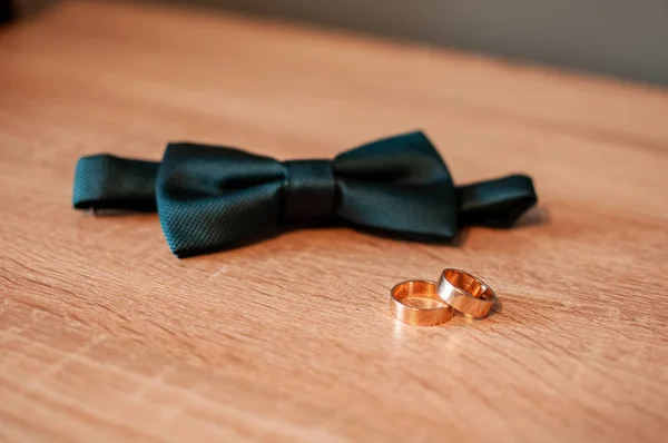 Motýlek a pár zlatých snubních prstenů — Stock fotografie