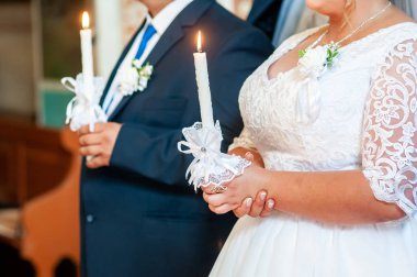 Gelin ve damat kilisede mum tutan