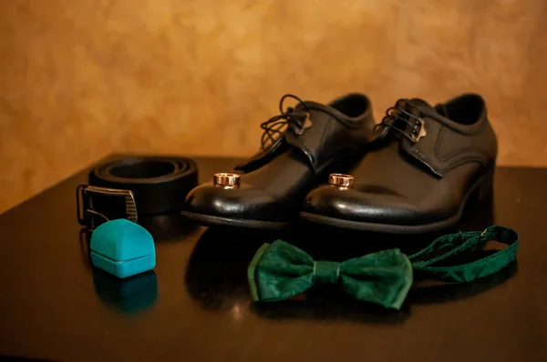 Ζεύγος από παπούτσια χρυσά δαχτυλίδια γάμου και πράσινο φιόγκο — Φωτογραφία Αρχείου