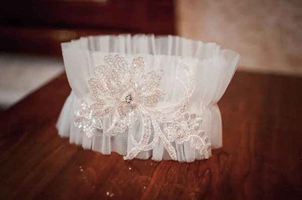 Fehér esküvői harisnyakötő az asztalon. — Stock Fotó