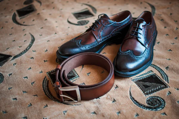 Pánské boty a hnědý pásek na koberci — Stock fotografie