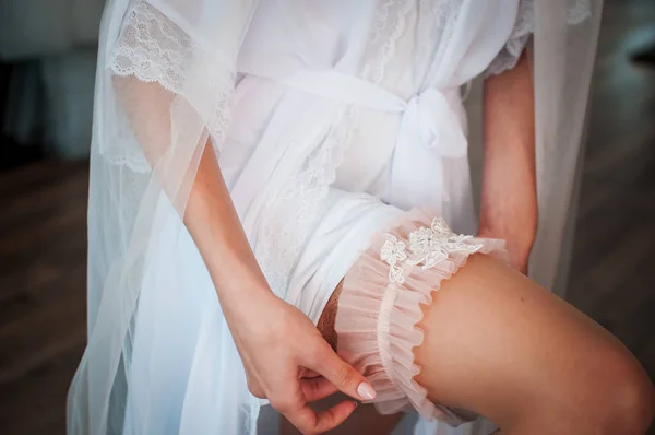 Bílý svatební podvazek na noze nevěsty — Stock fotografie