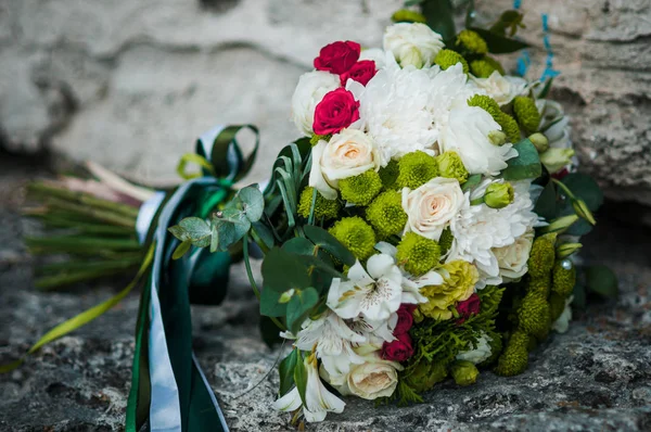 Kleurrijk boeket bloemen liggend op de rotsen — Stockfoto