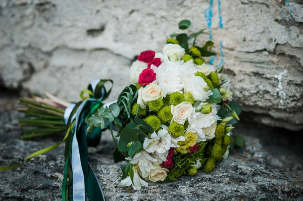 Buquê colorido de flores deitado sobre as rochas — Fotografia de Stock