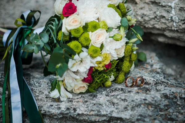 Buquê colorido de flores deitado sobre as rochas — Fotografia de Stock
