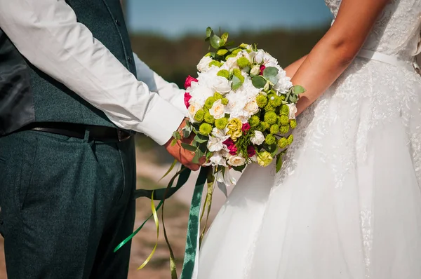 Noivo e noiva segurando buquê de casamento colorido na mão — Fotografia de Stock