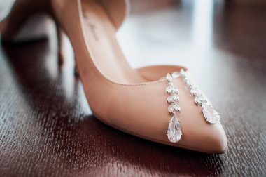 Küpeli beyaz topuklu ayakkabılar.