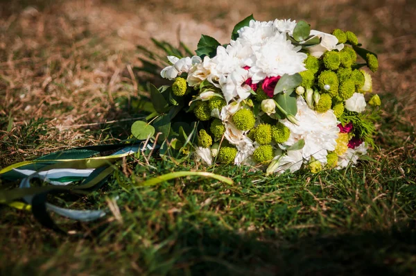 Buquê de flores brancas deitadas na grama — Fotografia de Stock